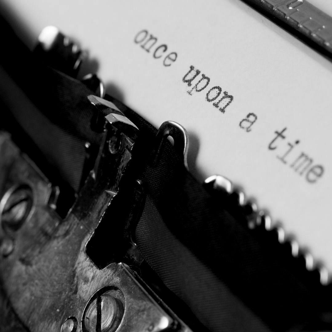 A type writer and a page of paper that reads "once upon a time".
